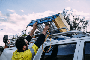 Professionnel qui charge une échelle sur son camion