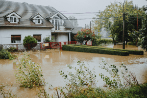 Maison avec jardin inondé après des fortes pluies, illustration des risques d’intempéries